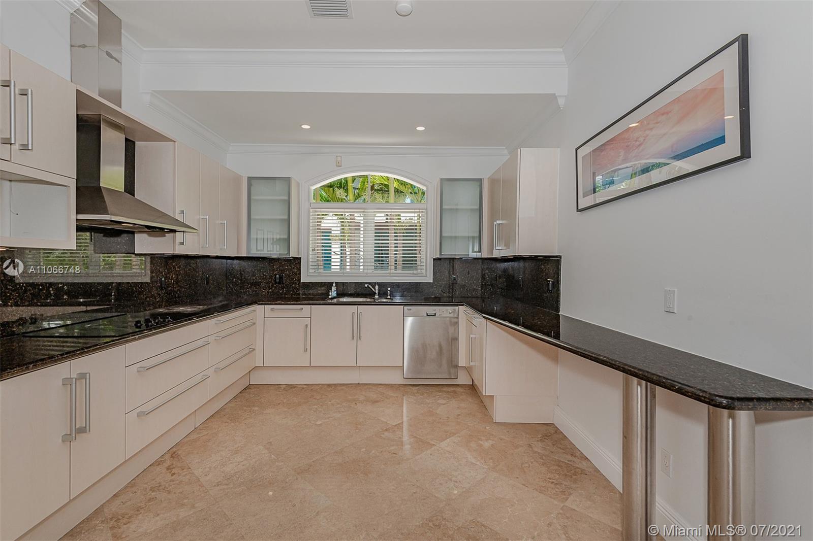 442 Woodcrest Road Key Biscayne, FL 33149 - Photo 13 of 48 a large white kitchen with granite countertop a stove a sink a window and a refrigerator