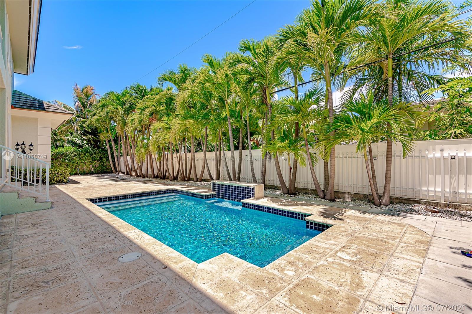 442 Woodcrest Road Key Biscayne, FL 33149 - Photo 3 of 48 a backyard of a house with table and chairs