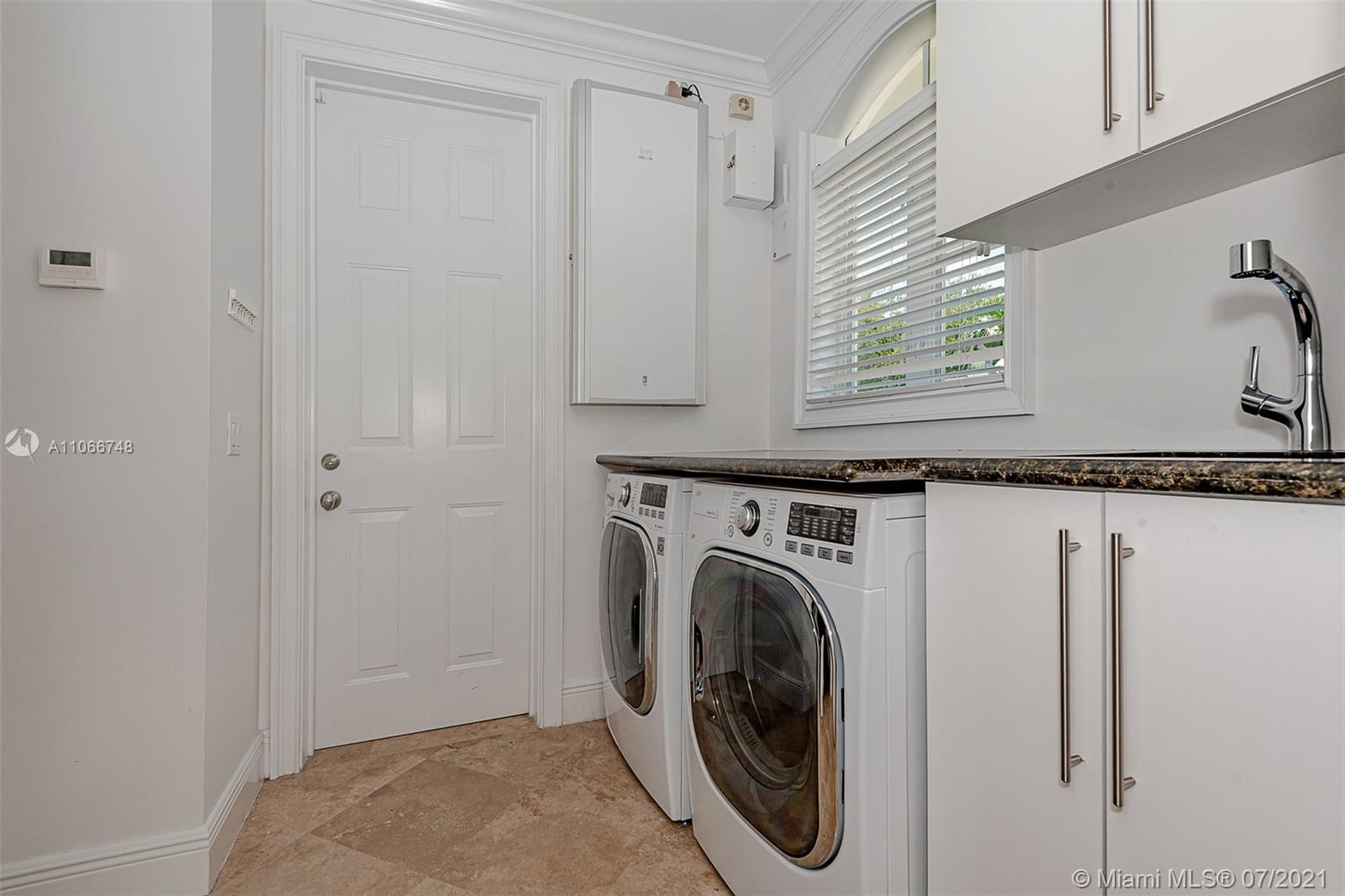 442 Woodcrest Road Key Biscayne, FL 33149 - Photo 22 of 48 a utility room with window dryer and washer