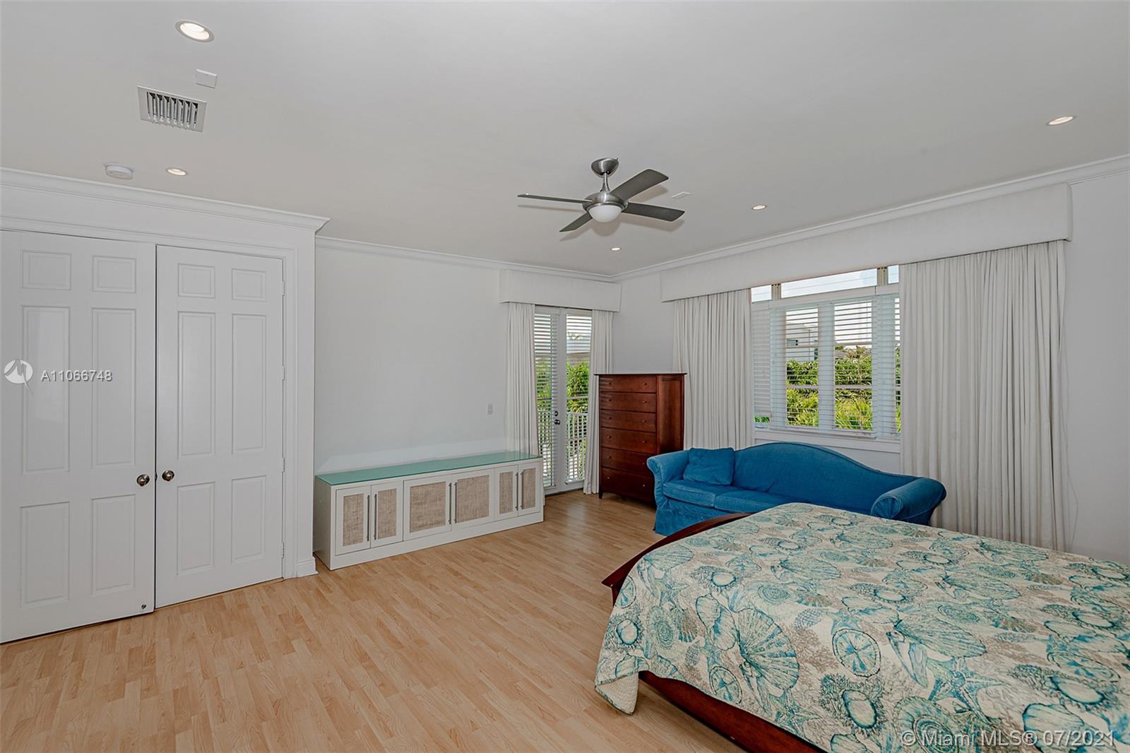 442 Woodcrest Road Key Biscayne, FL 33149 - Photo 29 of 48 a bedroom with a bed and a dresser with wooden floor