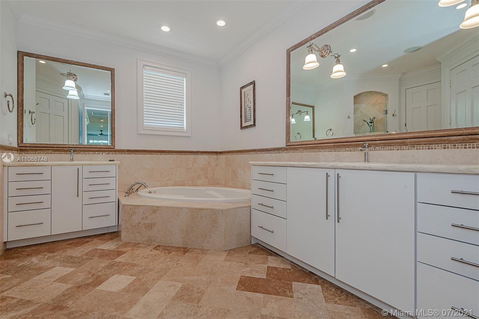 442 Woodcrest Road Key Biscayne, FL 33149 - Photo 31 of 48 a bathroom with a sink a large mirror and a bathtub