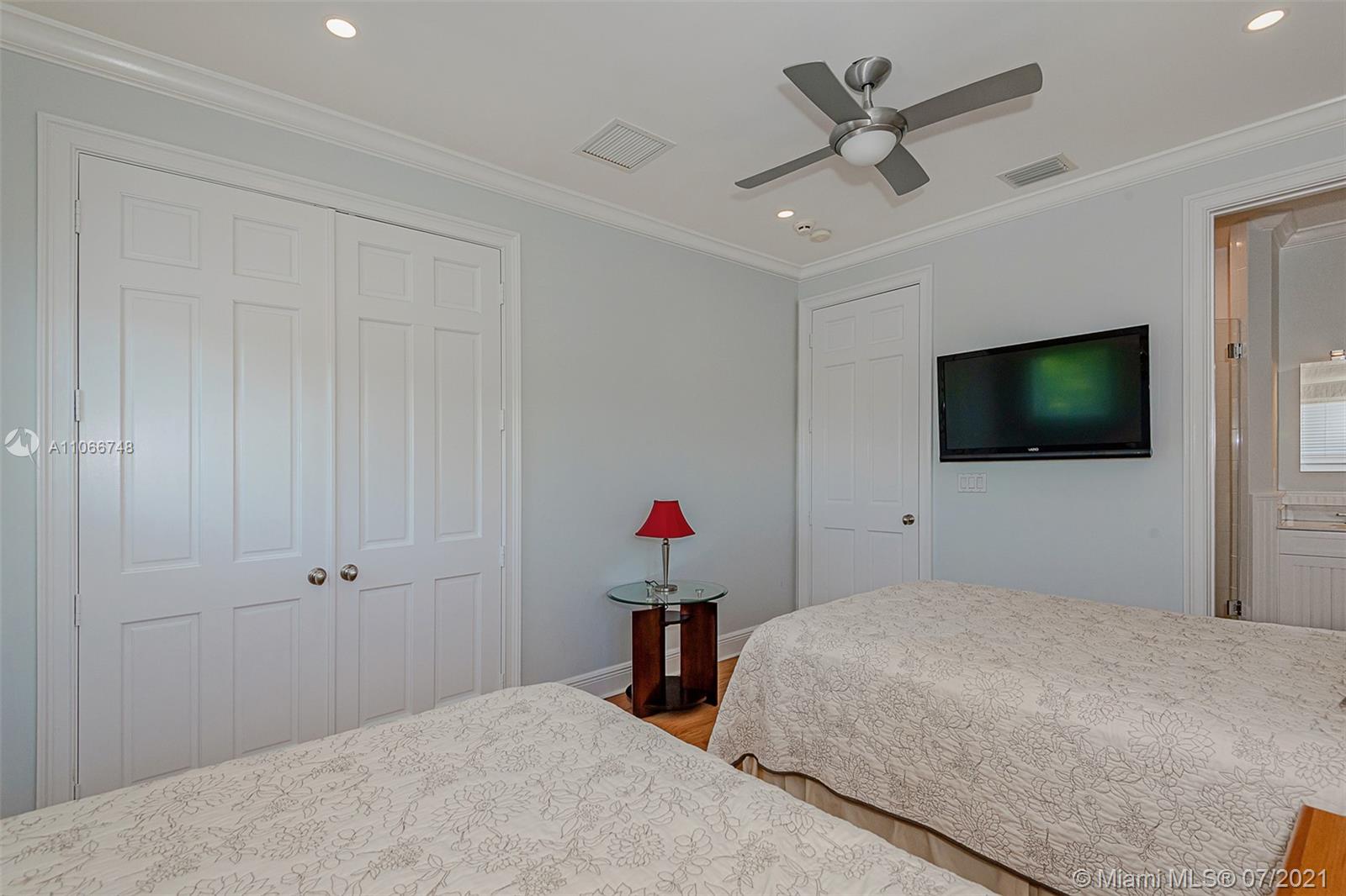 442 Woodcrest Road Key Biscayne, FL 33149 - Photo 34 of 48 a bedroom with a bed and a flat screen tv