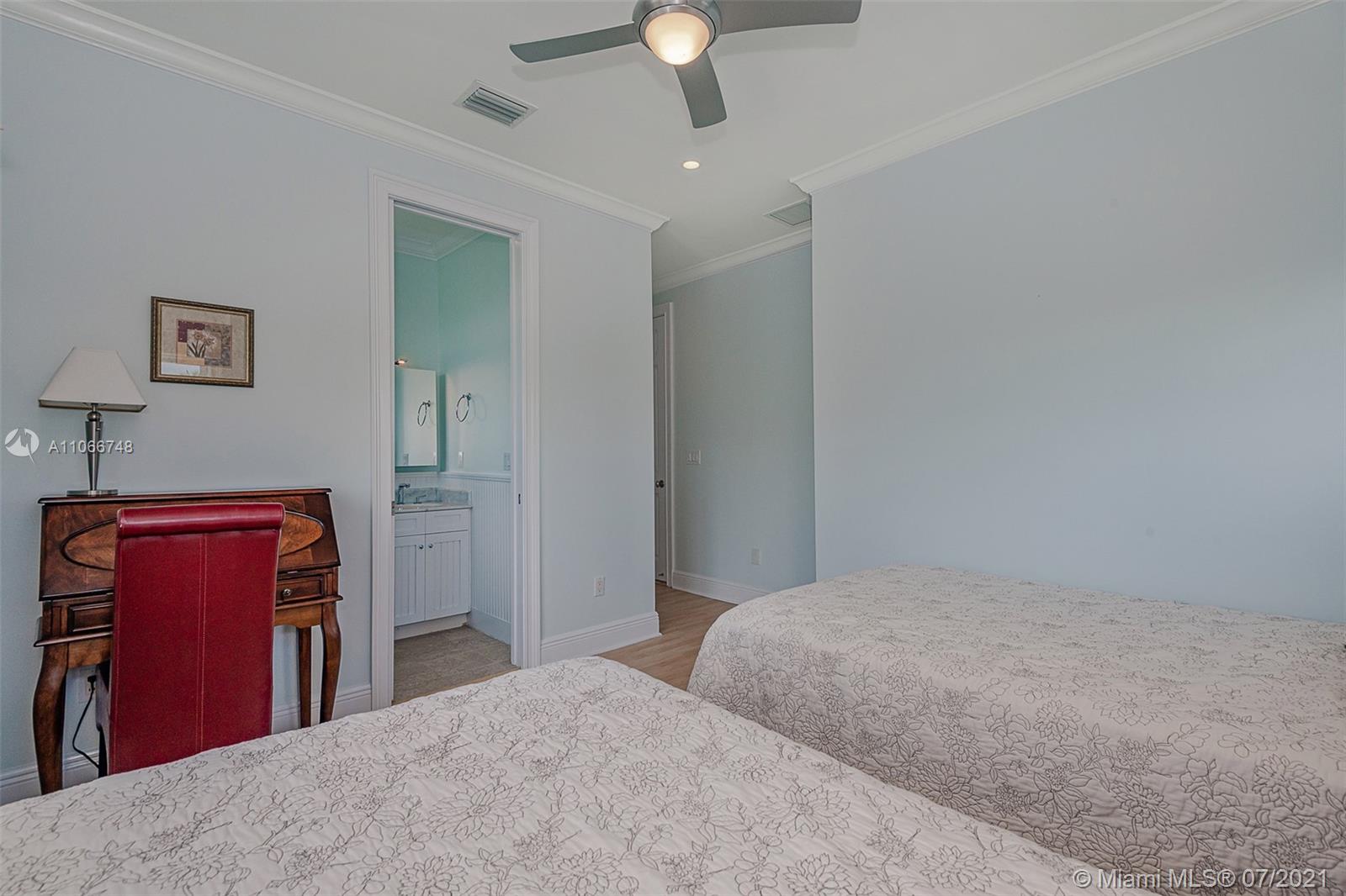 442 Woodcrest Road Key Biscayne, FL 33149 - Photo 37 of 48 a bedroom with a bed and a chandelier