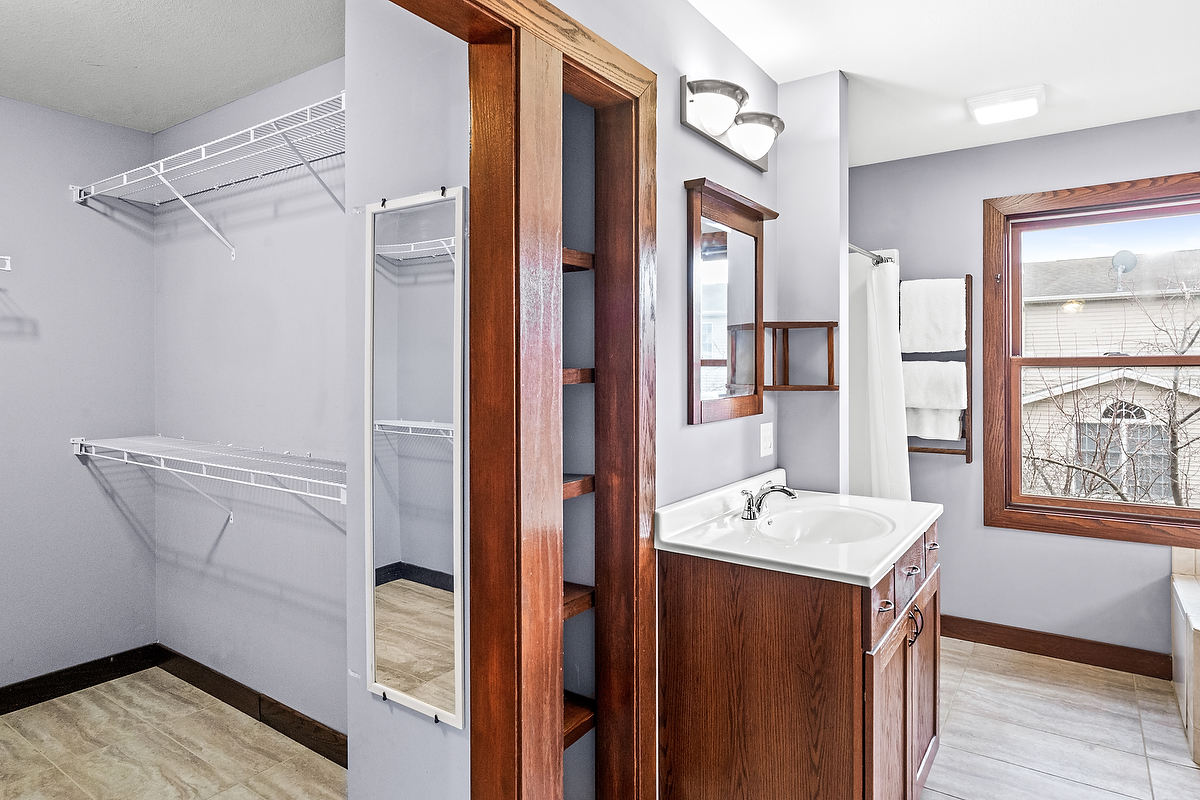 1515 Belclare Road Normal, IL 61761 - Photo 17 of 40 a bathroom with a sink a mirror and a shower