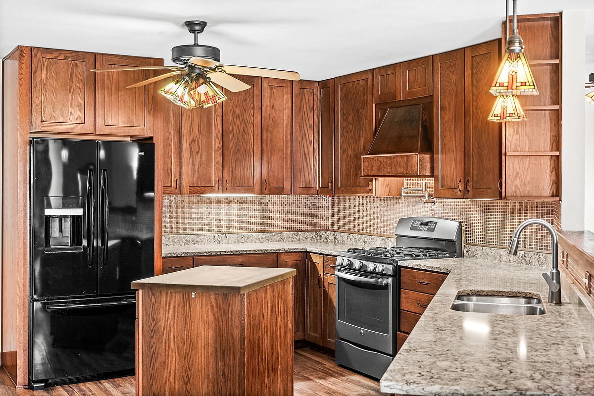 1515 Belclare Road Normal, IL 61761 - Photo 7 of 40 a kitchen with granite countertop stainless steel appliances and wooden cabinets