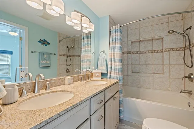 a bathroom with a granite countertop sink mirror toilet and bathtub