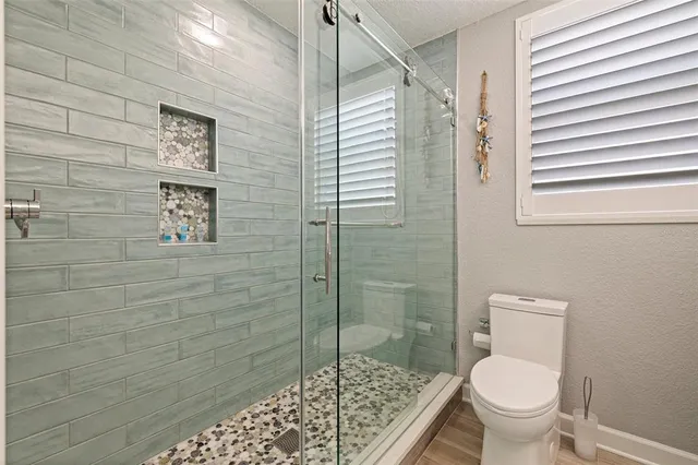 a bathroom with a toilet and a shower