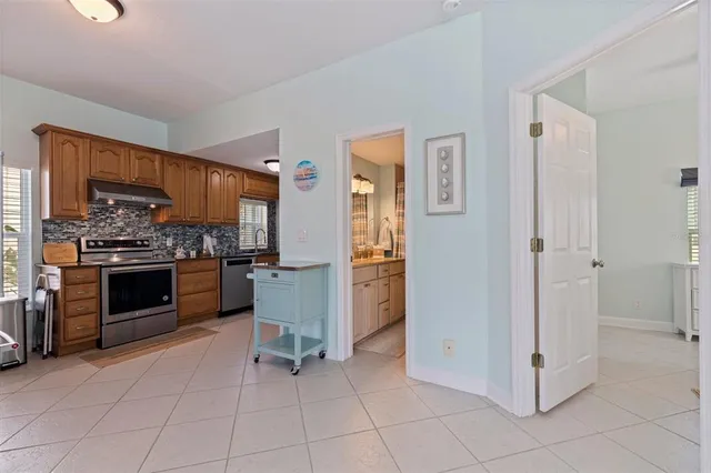a kitchen with granite countertop a stove top oven and refrigerator