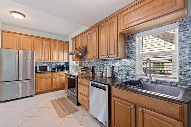 a kitchen with stainless steel appliances granite countertop a refrigerator sink and cabinets