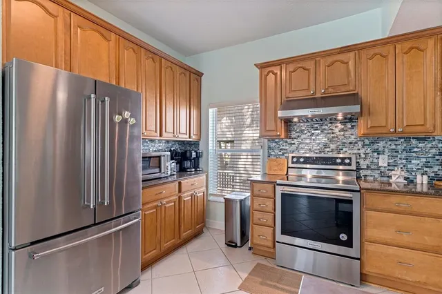 a kitchen with granite countertop a refrigerator stove and washer