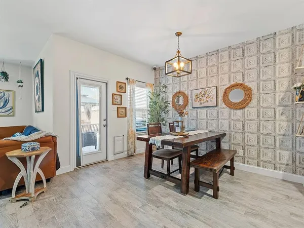 a view of a dining room and livingroom with furniture wooden floor and a clock