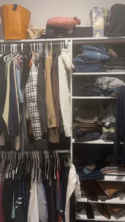 a view of walk in closet with clothes and shoes