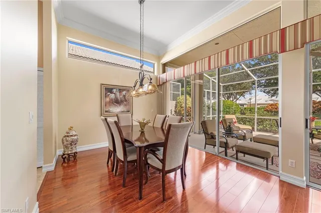 a dining room with furniture a chandelier and wooden floor