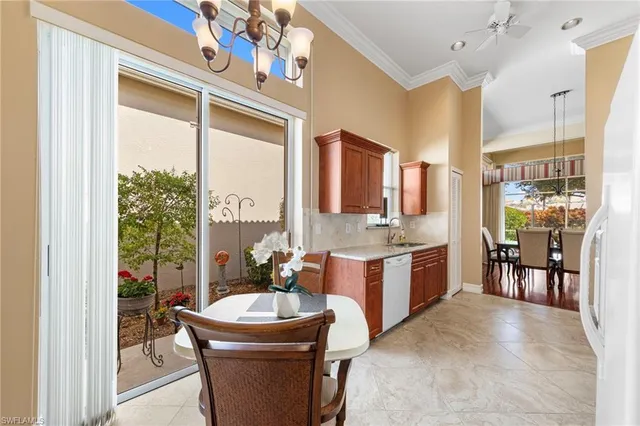 a room with kitchen island a large window cabinets and stainless steel appliances