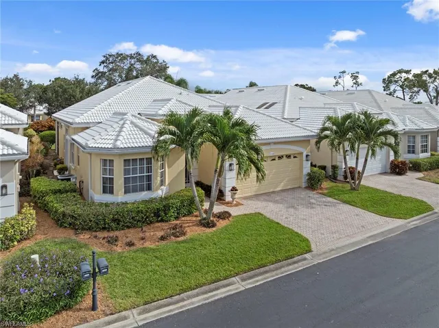 a view of a white house with a yard and potted plants