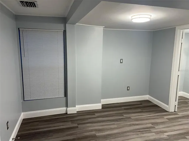 a view of a room with wooden floor and a window