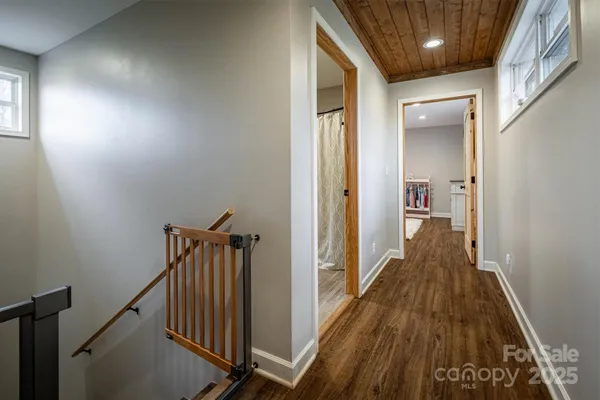 a view of a hallway with wooden floor and staircase