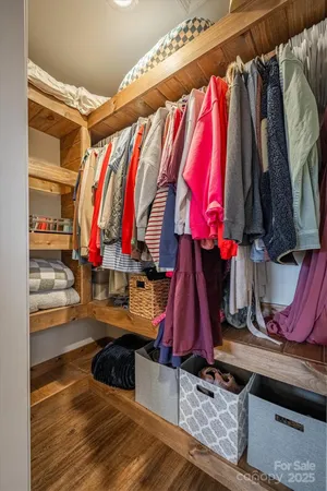 a view of walk in closet with clothes and shoes