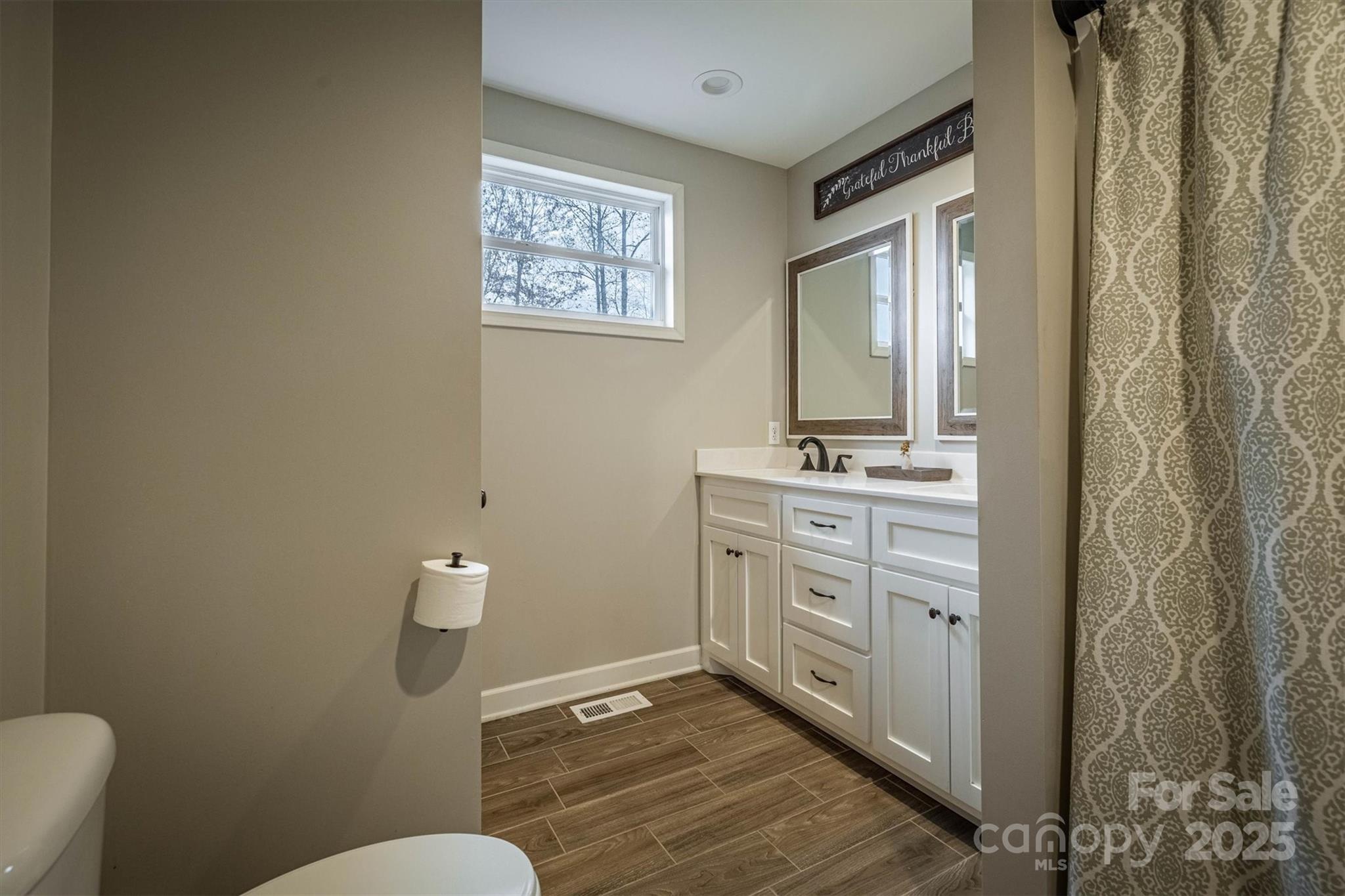 4447 Steeltown Road Lenoir, NC 28645 - Photo 39 of 42 a bathroom with a granite countertop sink mirror vanity and toilet