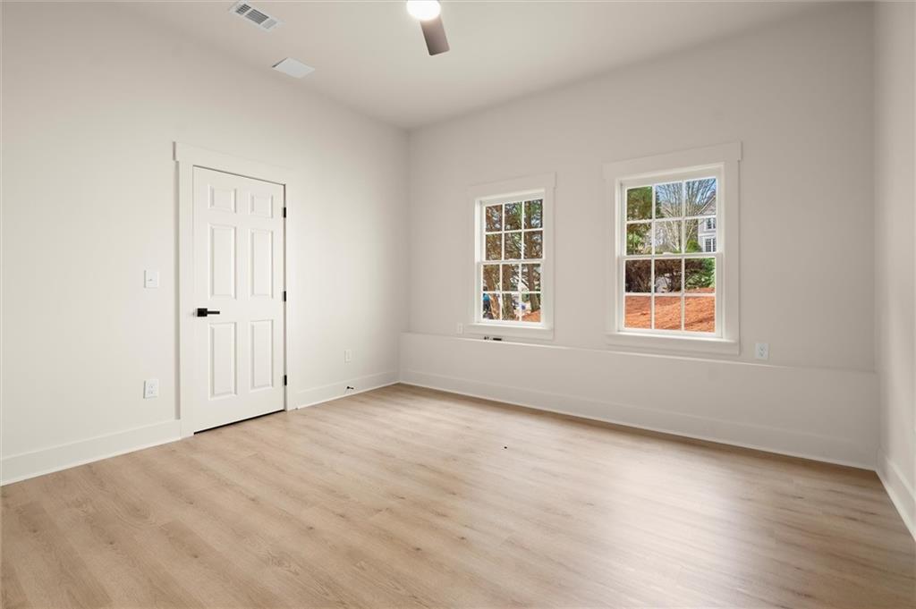 539 Schofield Drive Powder Springs, GA 30127 - Photo 36 of 41 an empty room with wooden floor and windows