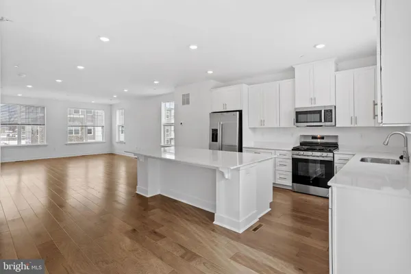 a kitchen with a refrigerator and a stove top oven