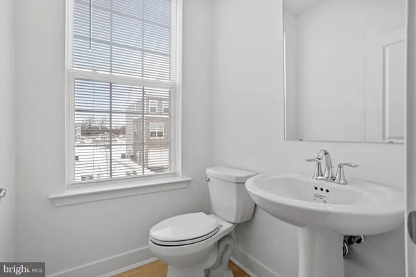 a bathroom with a sink a toilet and a window