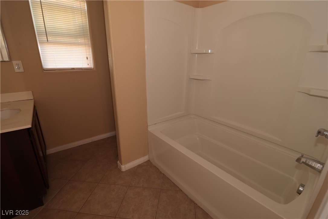 5940 Feral Garden Street North Las Vegas, NV 89031 - Photo 11 of 31 Bathroom with vanity, light tile patterned floors, and bathtub / shower combination