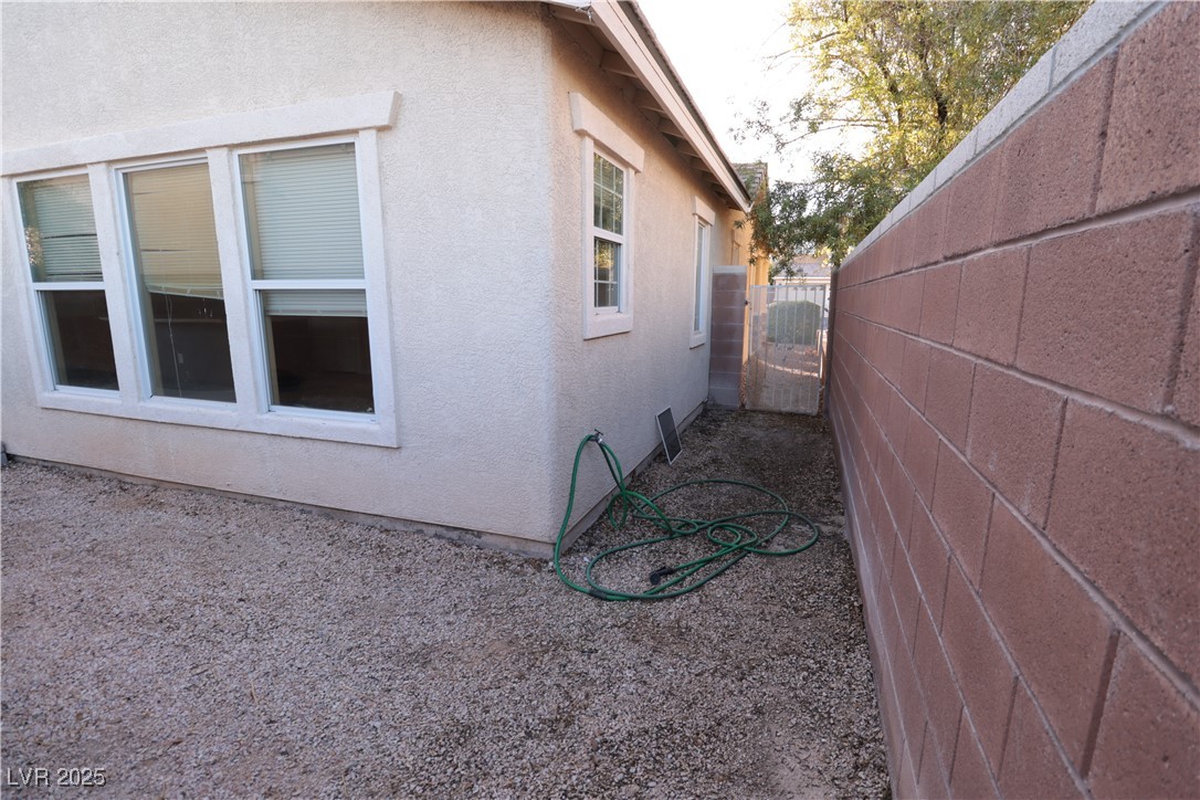 5940 Feral Garden Street North Las Vegas, NV 89031 - Photo 25 of 31 View of property exterior featuring stucco siding and a gate
