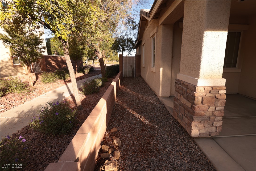 5940 Feral Garden Street North Las Vegas, NV 89031 - Photo 27 of 31 View of side of home featuring stucco siding and stone siding