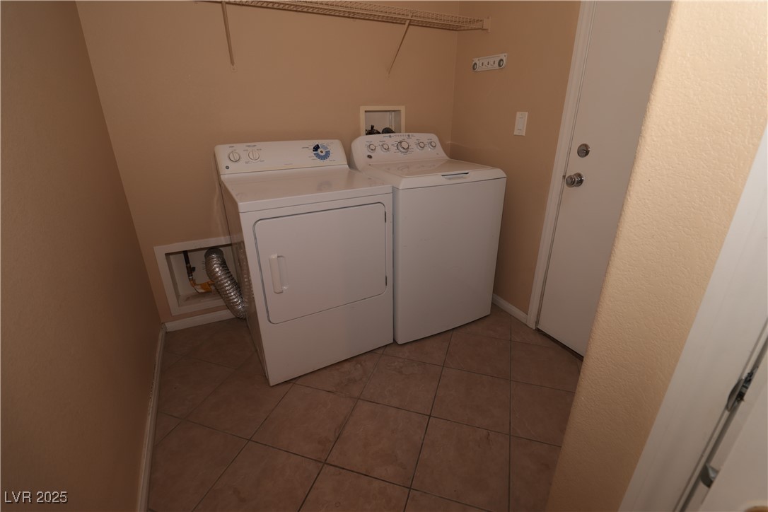 5940 Feral Garden Street North Las Vegas, NV 89031 - Photo 8 of 31 Laundry area featuring light tile patterned floors and washing machine and dryer