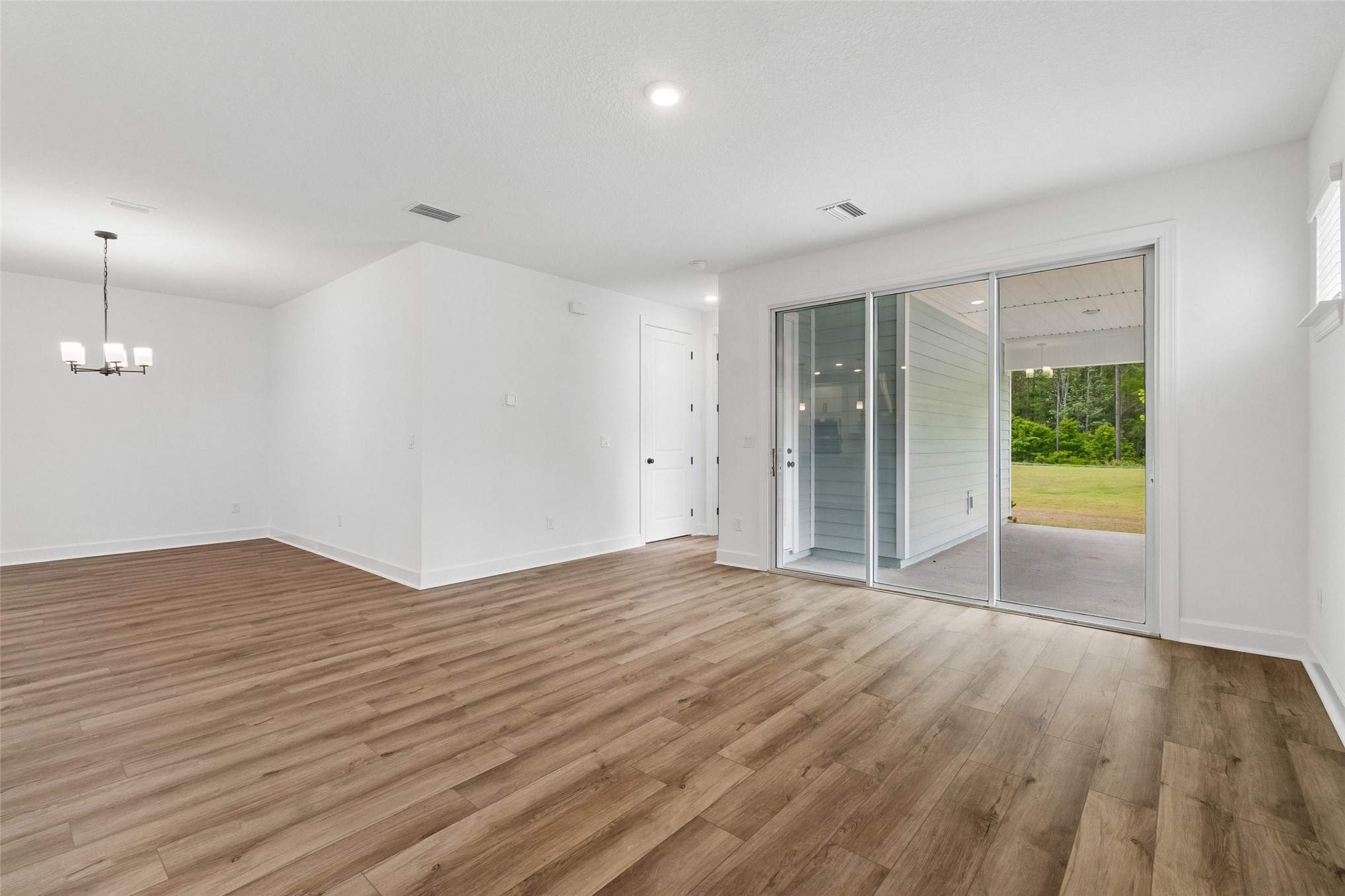 718 Windchime Street Yulee, FL 32097 - Photo 12 of 28 wooden floor in an empty room with a window