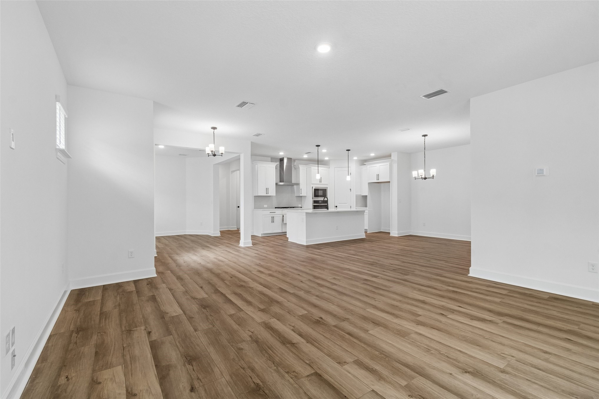 718 Windchime Street Yulee, FL 32097 - Photo 13 of 28 a view of kitchen and empty room with wooden floor