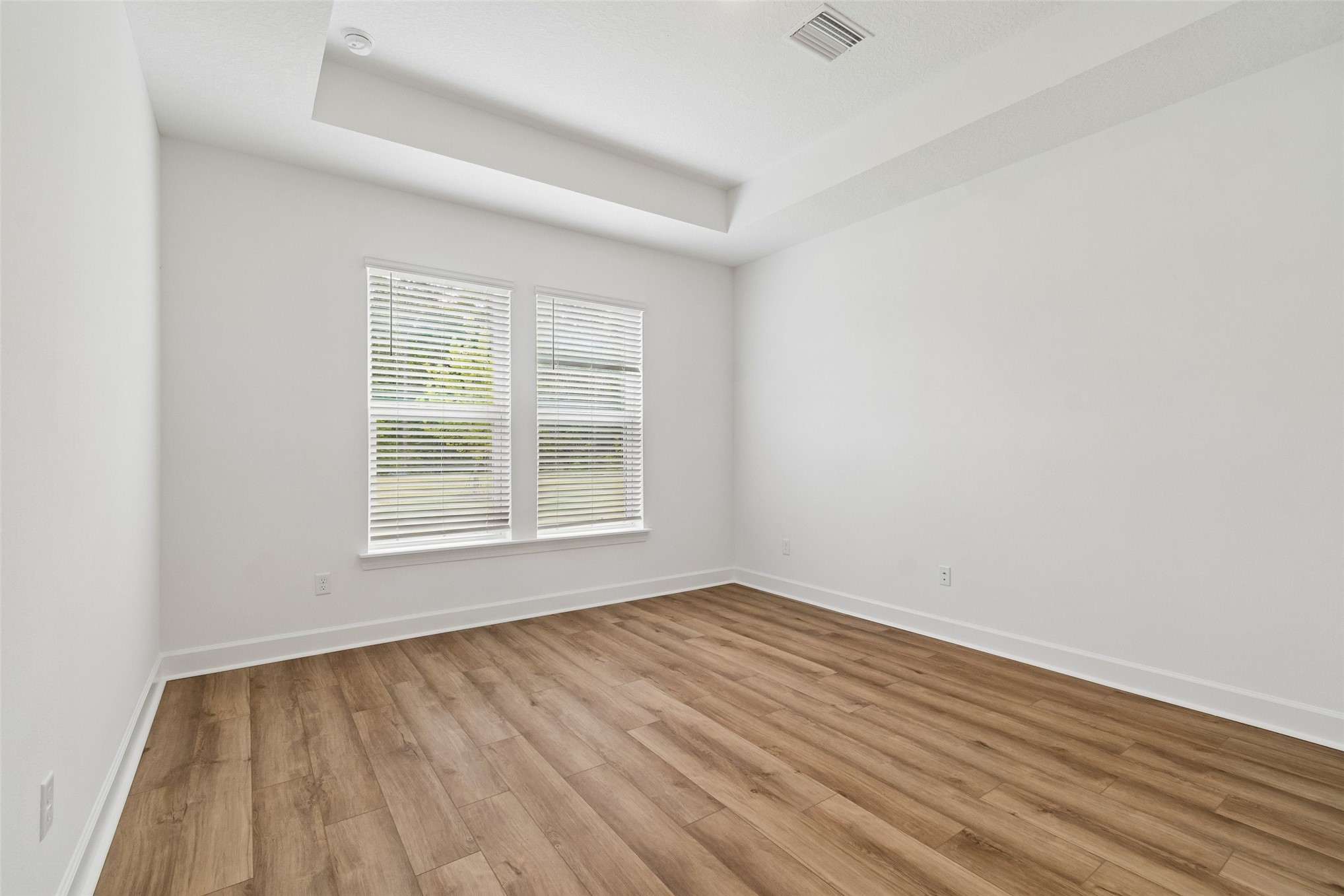 718 Windchime Street Yulee, FL 32097 - Photo 15 of 28 an empty room with wooden floor and windows