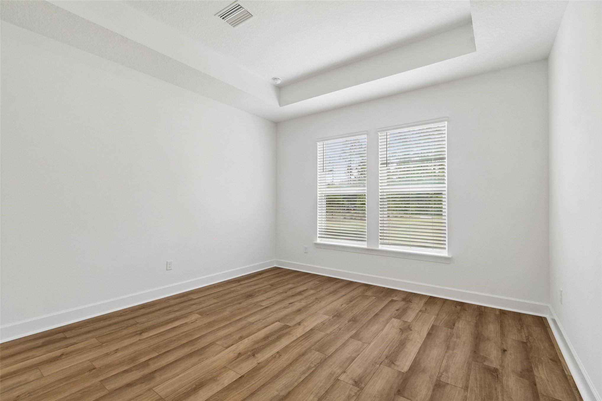 718 Windchime Street Yulee, FL 32097 - Photo 17 of 28 an empty room with wooden floor and windows