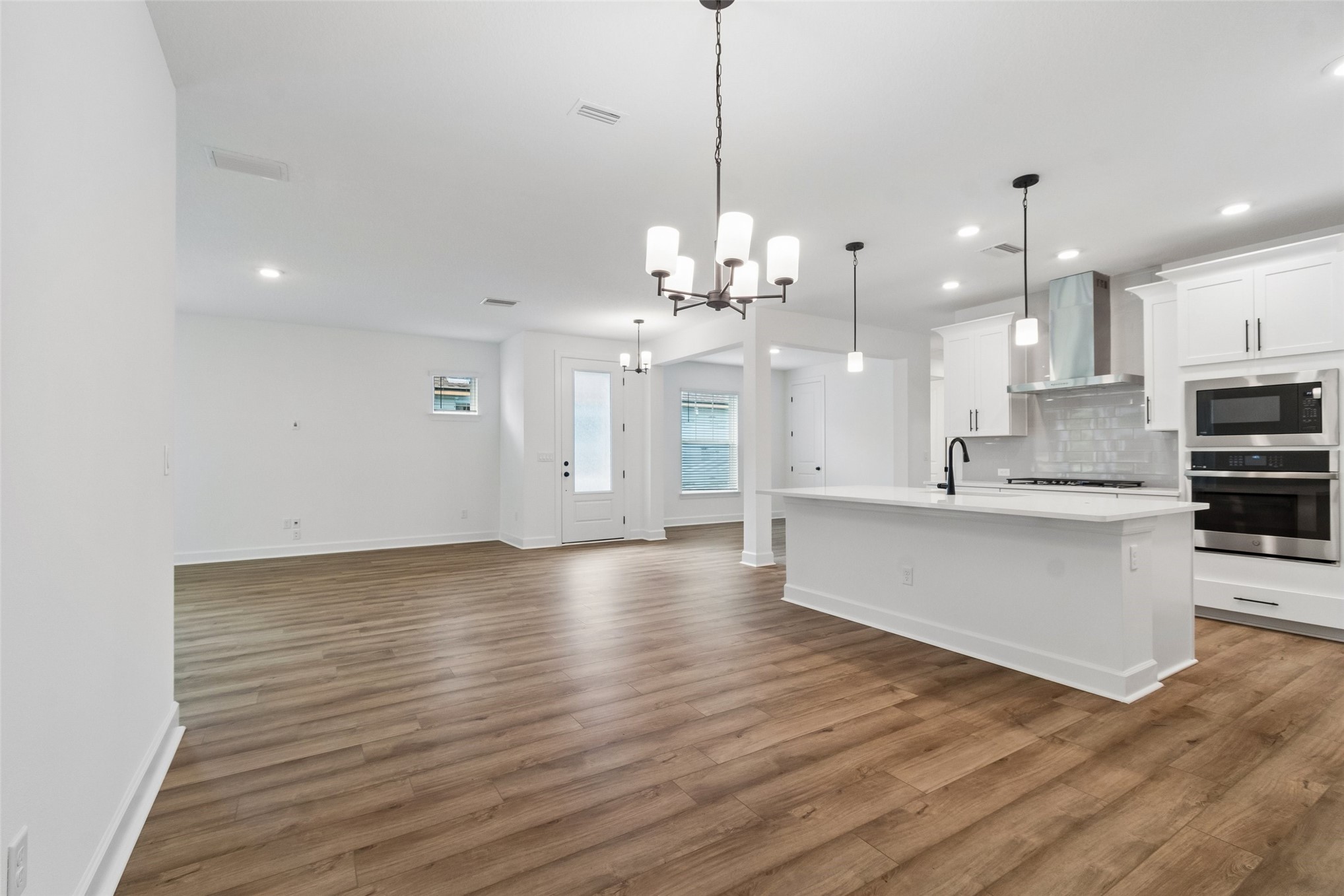 718 Windchime Street Yulee, FL 32097 - Photo 5 of 28 a large kitchen with granite countertop a large counter top a sink stainless steel appliances and cabinets