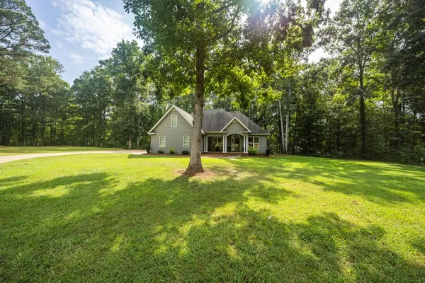 a front view of a house with yard and green space