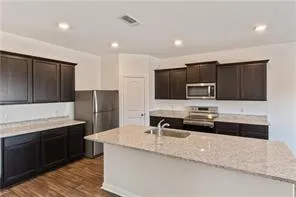 a kitchen with stainless steel appliances granite countertop a sink and a stove