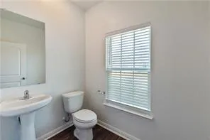 a bathroom with a sink a toilet and a window