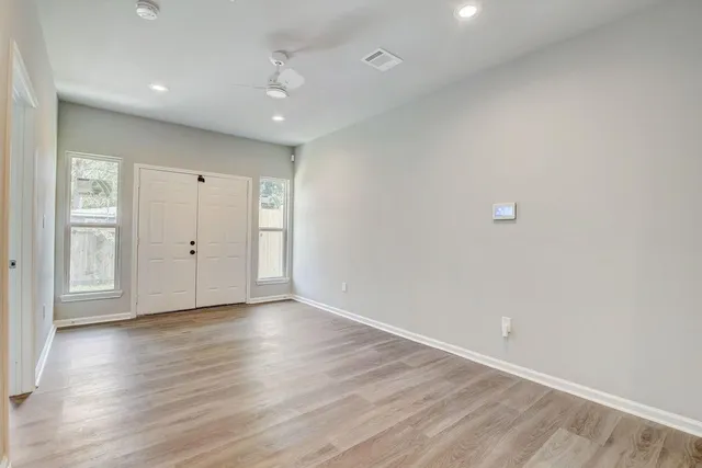 a view of an empty room with wooden floor