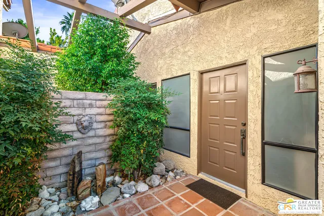 a couple of potted plants in front of door