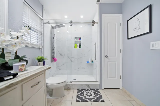 a bathroom with a sink a toilet and shower