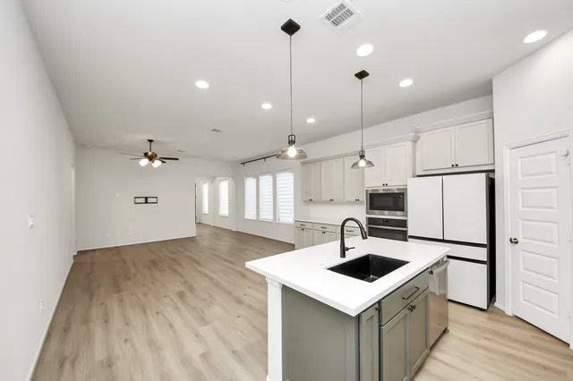 a kitchen with stainless steel appliances kitchen island a sink cabinets and wooden floor