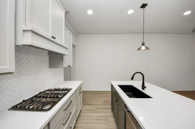 a kitchen with stainless steel appliances a sink a stove and a refrigerator
