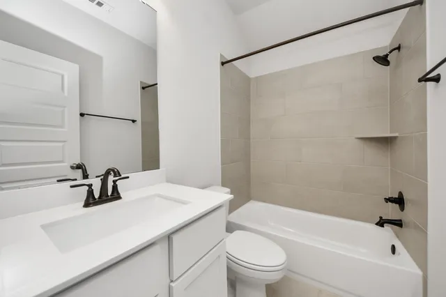 a bathroom with a sink a toilet a mirror a bathtub and shower