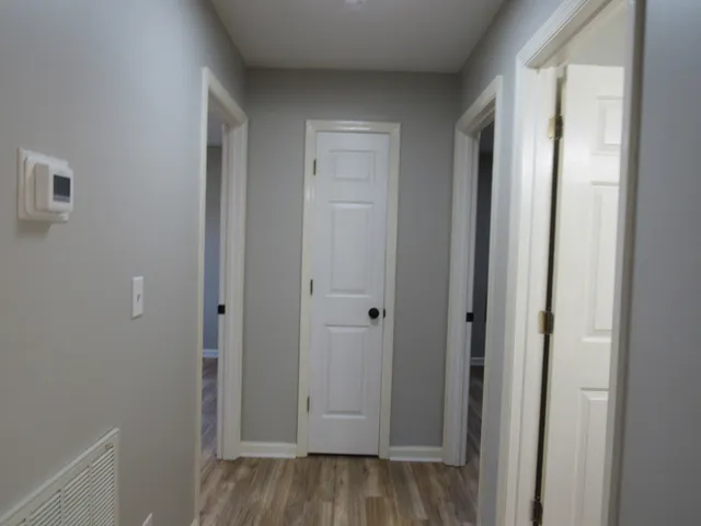 a view of a hallway with wooden floor