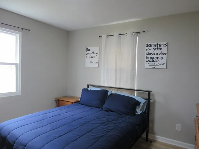 a bed sitting in a bedroom next to a window