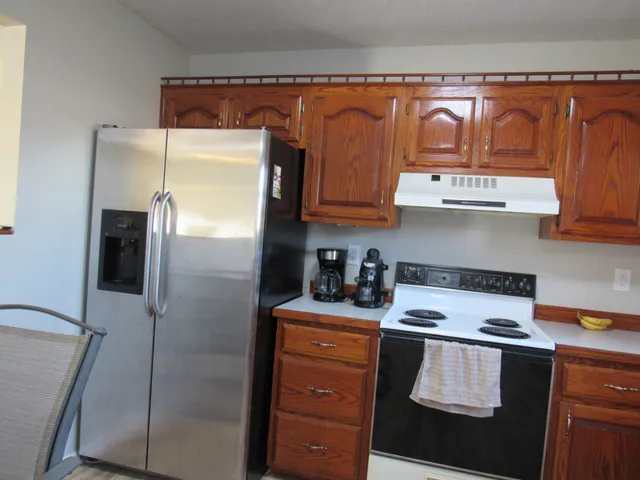 a kitchen with stainless steel appliances granite countertop a refrigerator and a stove