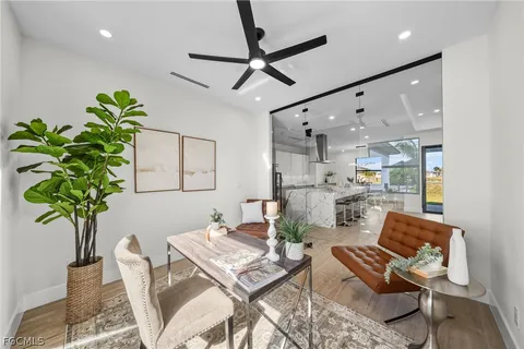 a living room with furniture a potted plant and a chandelier