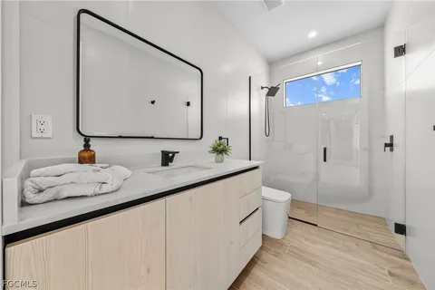 a bathroom with a double vanity sink mirror and toilet