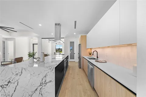 a dining hall with stainless steel appliances kitchen island granite countertop a sink and cabinets